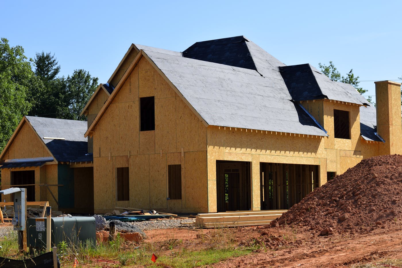 Partially built wooden house under construction showcasing framing and build progress