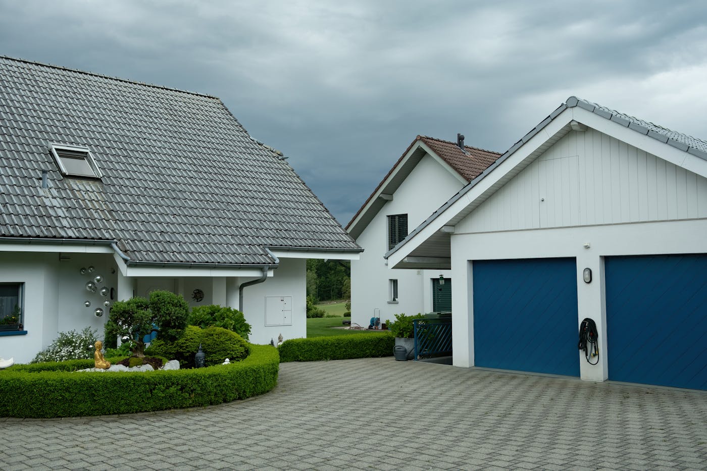 Lovely suburban houses with blue garage doors under cloudy sky in NSW