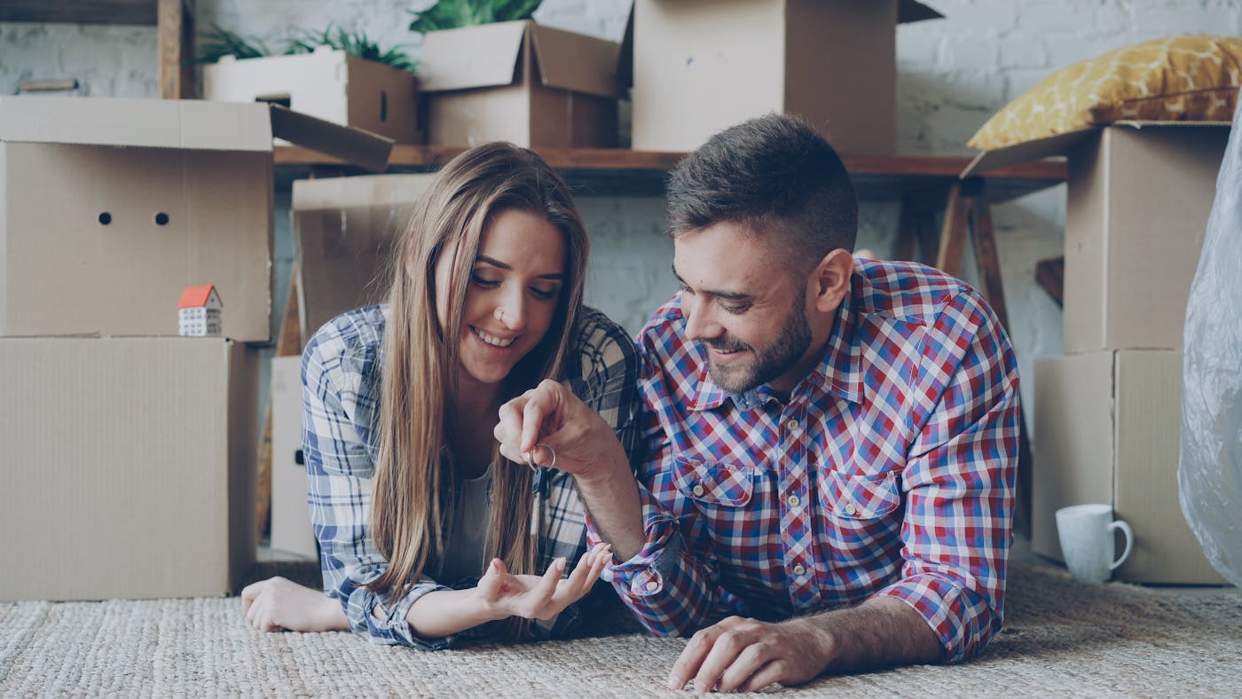 Couple celebrating new home ownership with keys after completing their building contract