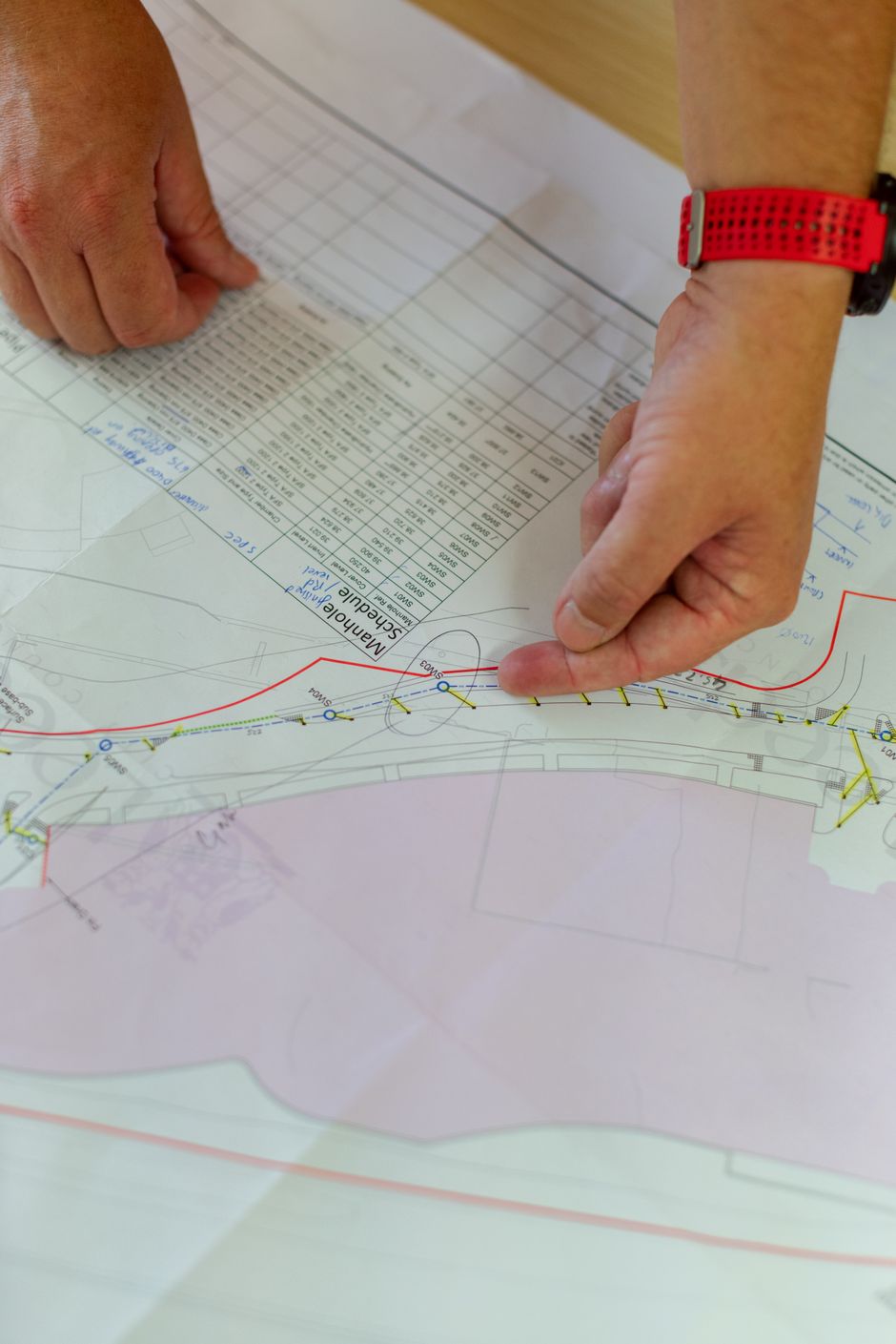 Civil engineer reviewing construction plans and blueprints on site