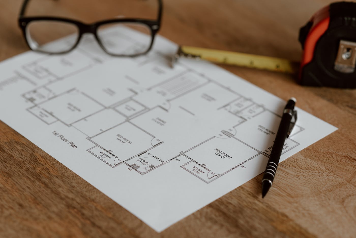 Builder quote document with ruler and pencil on residential house plans