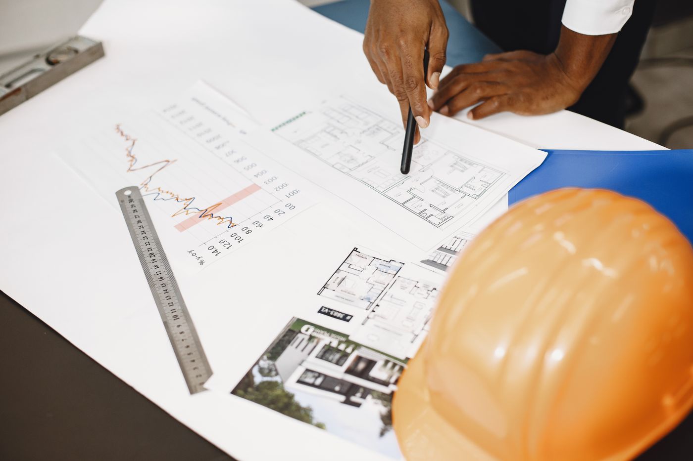 Architect analyzing building blueprints with planning tools on office desk