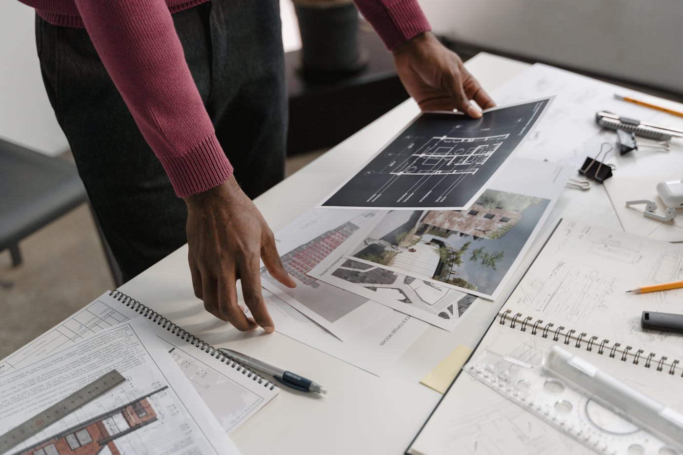 Architect reviewing blueprints and design plans at a desk