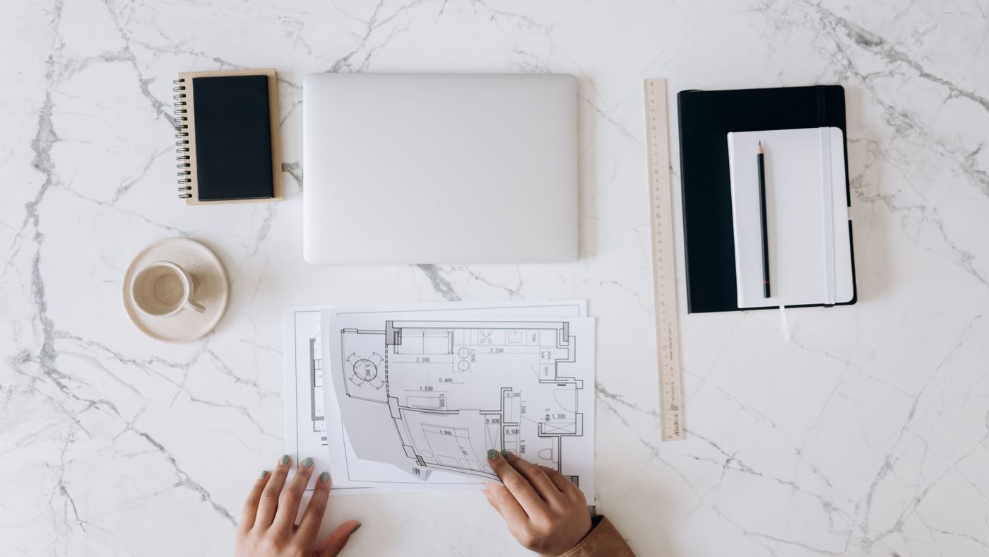 Architect desk with blueprints, laptop, and design documents for townhouse development planning
