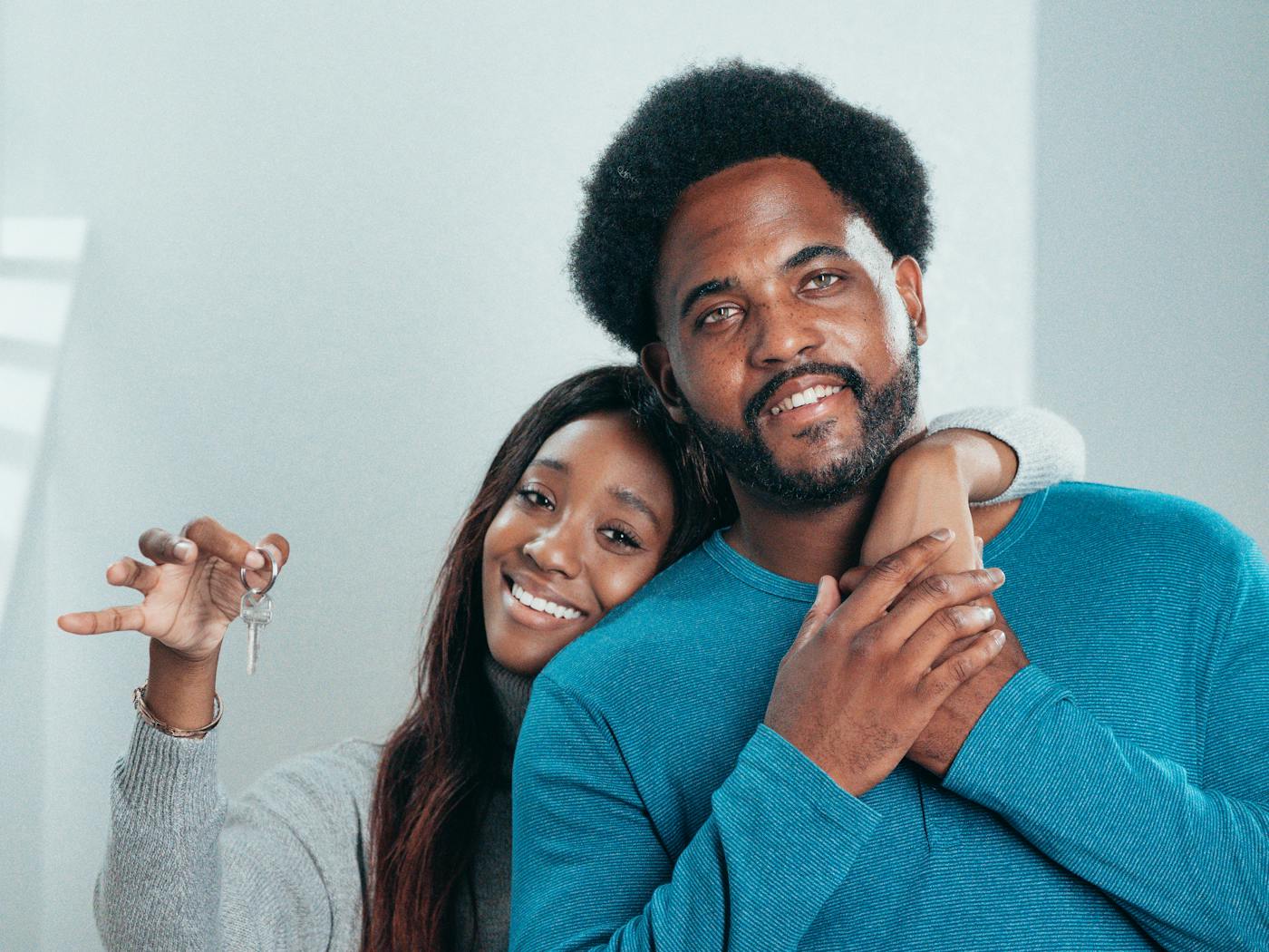 Joyful couple proudly holding keys to their new home in Sydney
