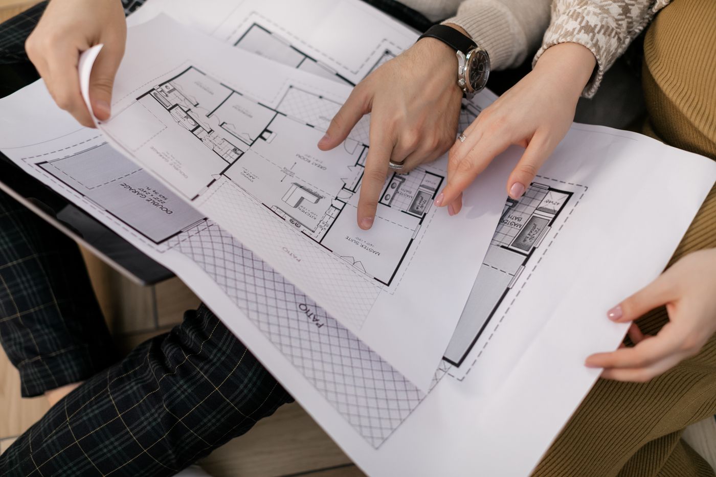 Two people examining architectural blueprints during a custom home design consultation