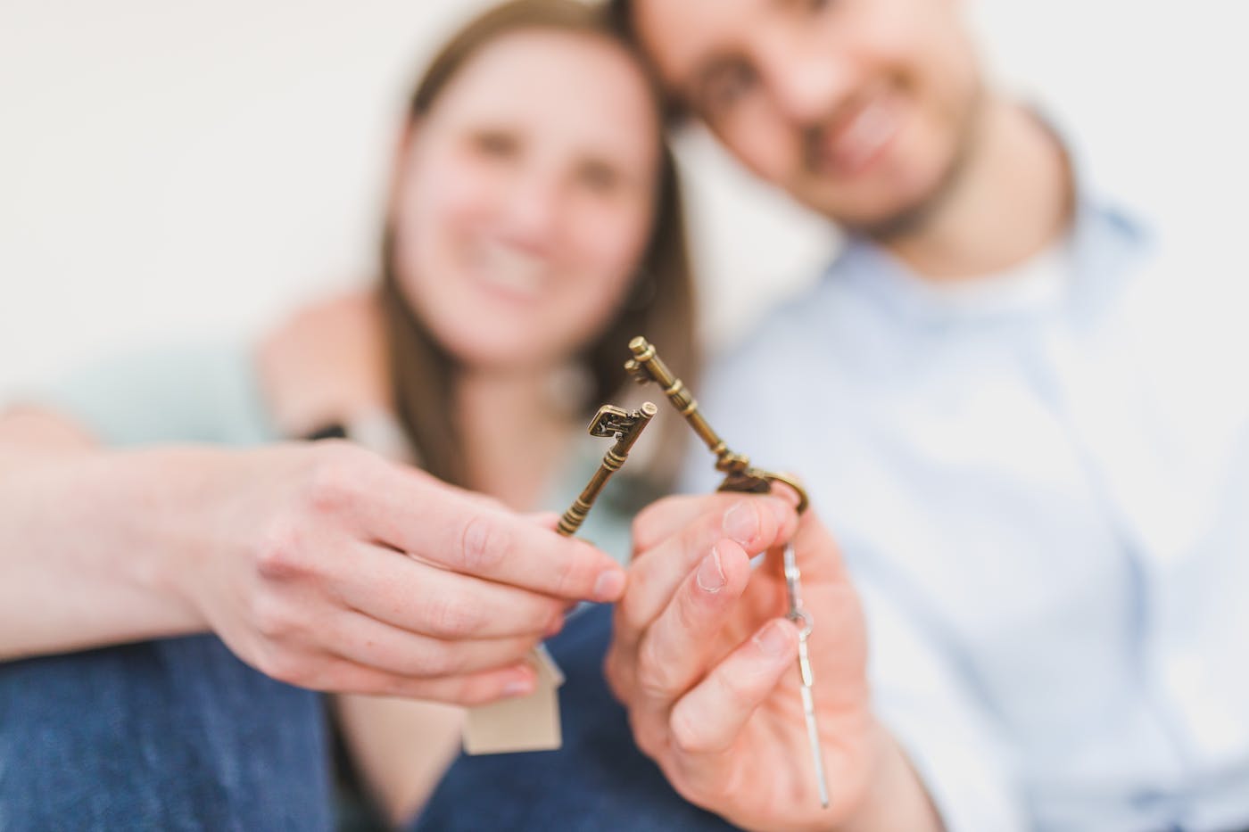 Smiling couple celebrates new home purchase with keys, protected by NSW home building legislation