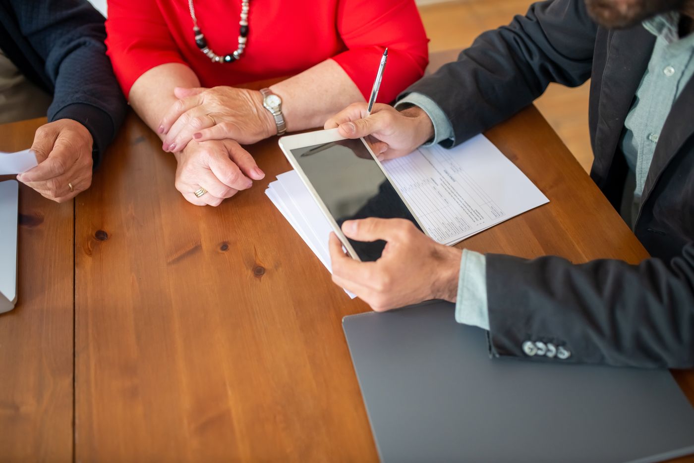 Builder and clients reviewing a home building contract at a meeting table