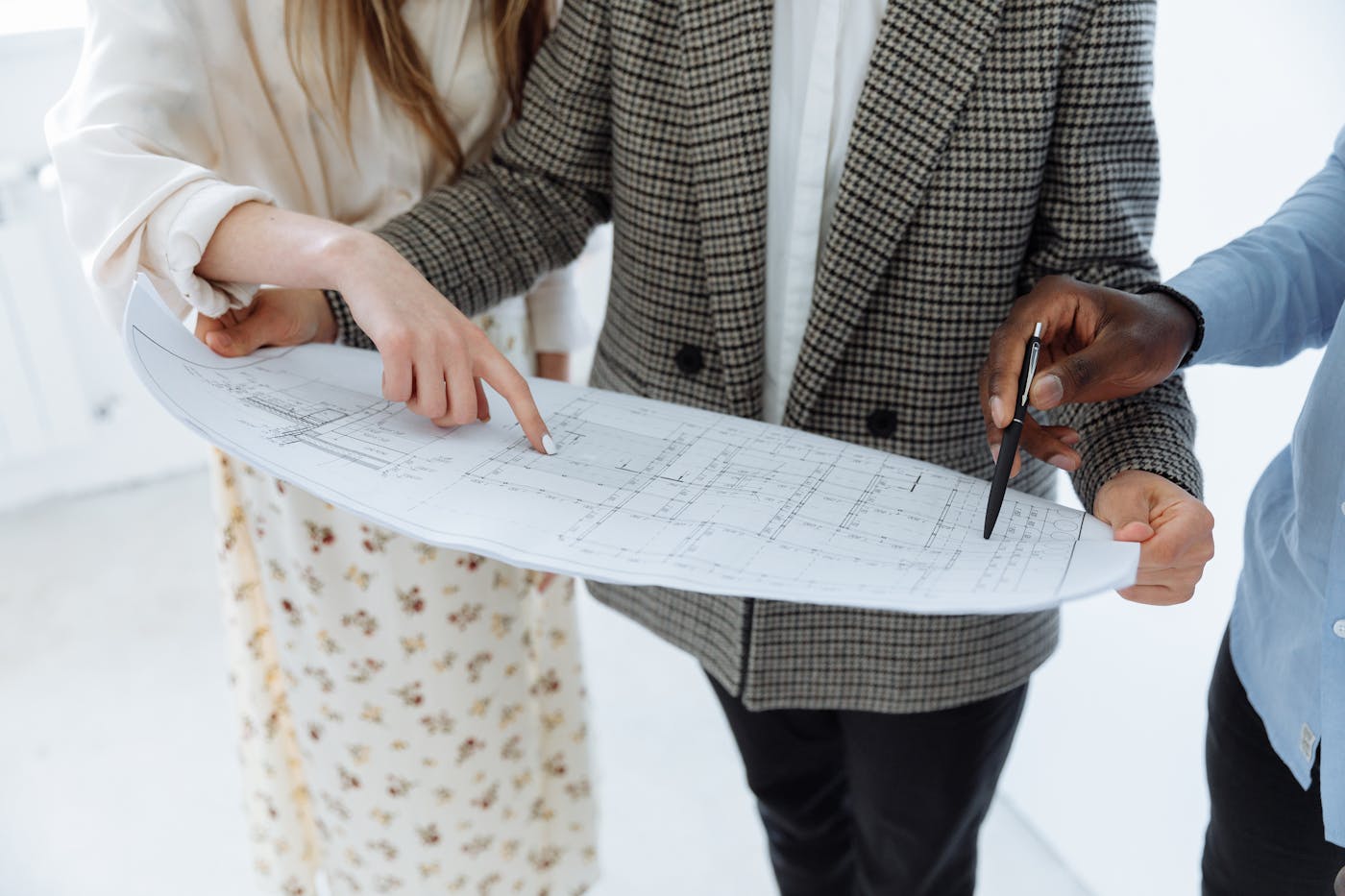 Architects reviewing residential building floor plans at a design table