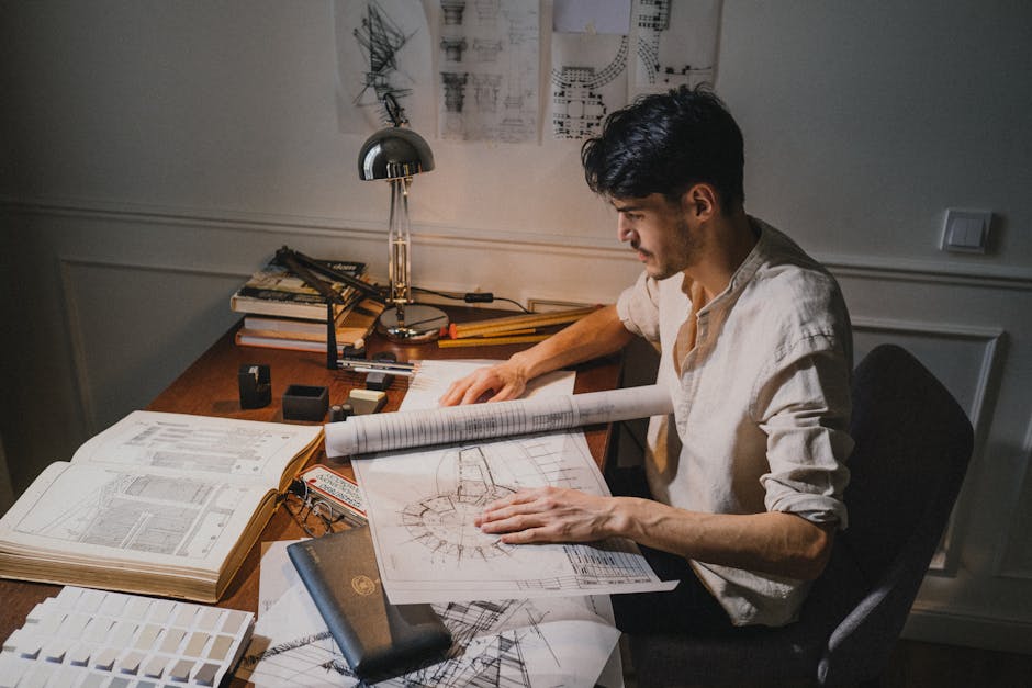 Architect reviewing blueprints and drawings at a design table
